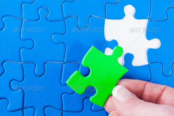 Woman Placing Piece in Jigsaw Puzzle