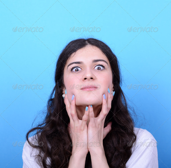 Portrait of angry girl against blue background (Misc) Photo Download