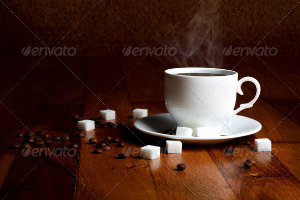 Fresh cup of hot coffee with sugar and natural grains on a woode