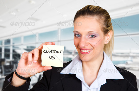 Woman displaying a contact us business card in the airport