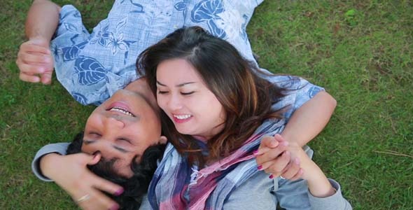 Young Couple Relaxing On Lawn In A City Park Young Couple Relaxing On Lawn In A City Park