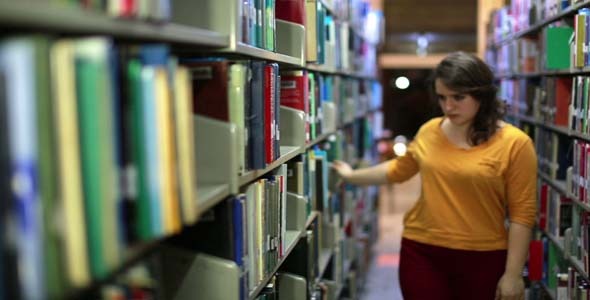 Female Student Wandering Between Shelves Female Student Wandering Between Shelves