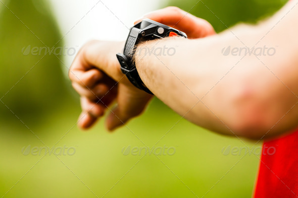 Cross country runner looking at sport watch