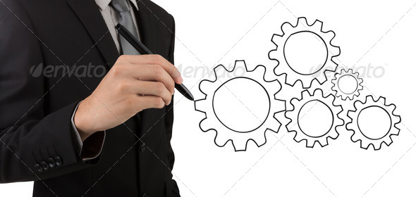 Businessman hand drawing gear to success concept
