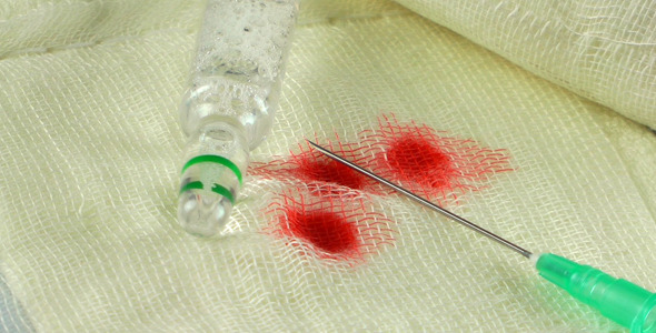 Needle Medicine and Blood Drops on Gauze Bandage Needle Medicine and Blood Drops on Gauze Bandage
