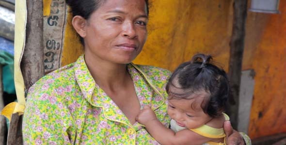 Mother Feeding Baby In Cambodian Slums Dump Area Mother Feeding Baby In Cambodian Slums Dump Area