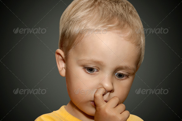 Young boy picking his nose.