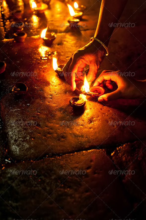 People burning oil lamps as religious ritual in Hindu temple
