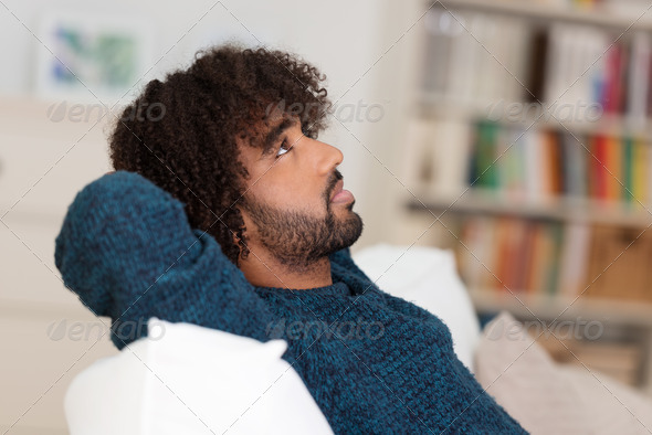 Young African American man sitting thinking - Stock Photo - Images