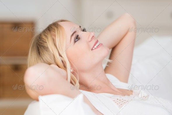 Pretty blond woman lying daydreaming - Stock Photo - Images