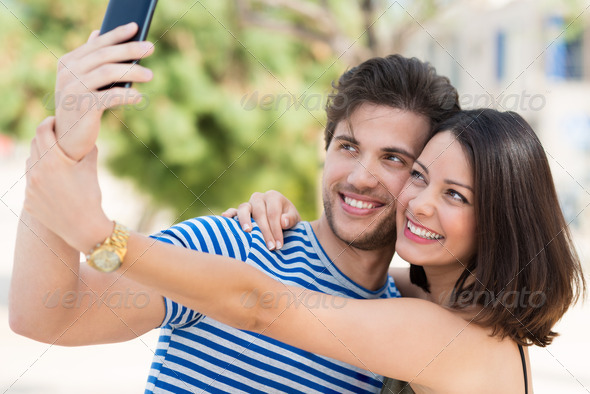 Vivacious couple taking a selfie on their mobile - Stock Photo - Images