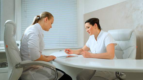 Two Cosmeticians Talking In The Office Room Two Cosmeticians Talking In The Office Room