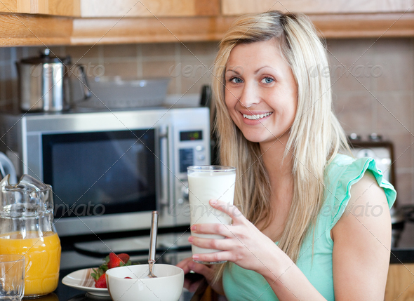 Smiling woman having an healthy breakfast in a kitchen (Misc) Photo Download