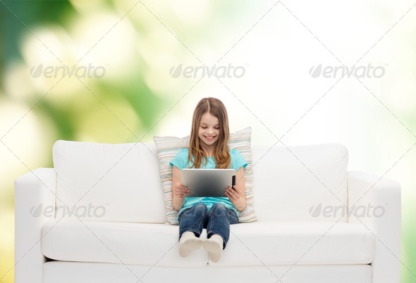 little girl sitting on sofa with tablet pc (Misc) Photo Download