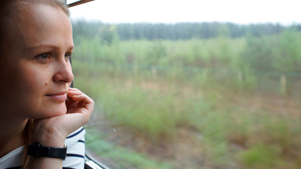 Young Woman Looking Out The Window Of Moving Train Young Woman Looking Out The Window Of Moving Train