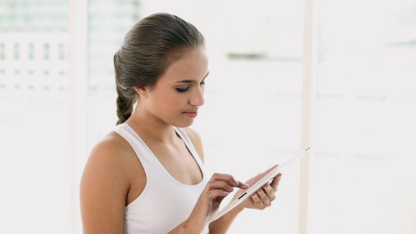 Fit Young Woman Using Her Digital Tablet Fit Young Woman Using Her Digital Tablet