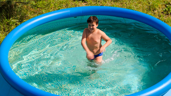 Boy Having Fun In Outdoor Pool On A Hot Summer Day Boy Having Fun In Outdoor Pool On A Hot Summer Day