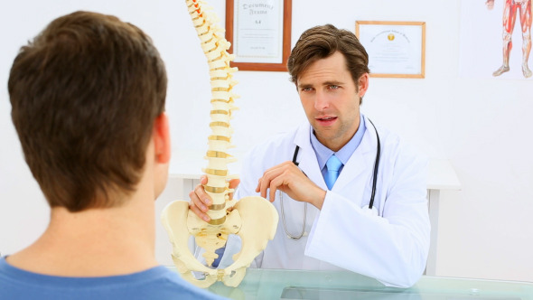 Doctor Showing Patient A Spine Model Doctor Showing Patient A Spine Model