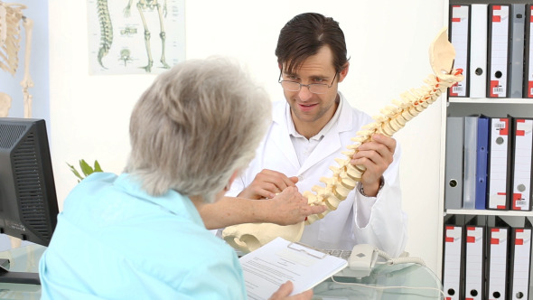 Chiropractor Showing Spine Model To His Patient Chiropractor Showing Spine Model To His Patient