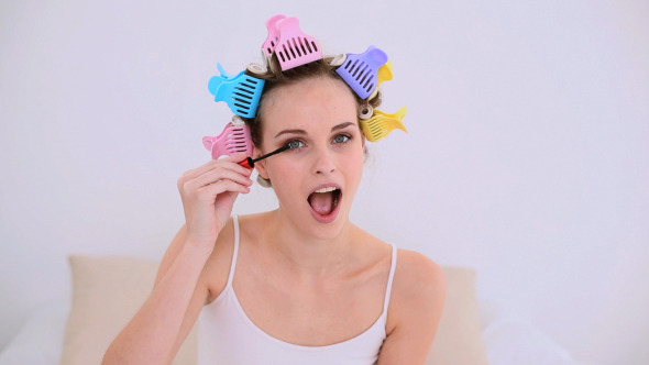 Young Model In Hair Rollers Putting On Mascara Young Model In Hair Rollers Putting On Mascara