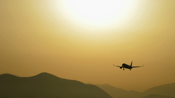 Airplane Flying at Low Altitude at Sunset Airplane Flying at Low Altitude at Sunset