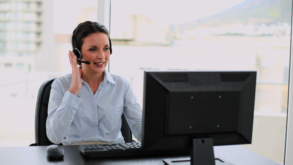 Call Center Agent On A Call At Her Desk Call Center Agent On A Call At Her Desk