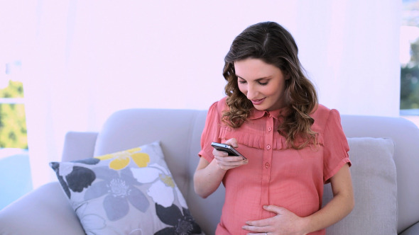 Pretty Pregnant Model Sitting Texting