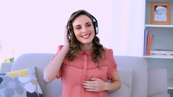 Pretty Pregnant Model Sitting Listening To Music