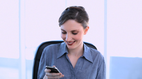 Happy Businesswoman Texting On Her Smartphone
