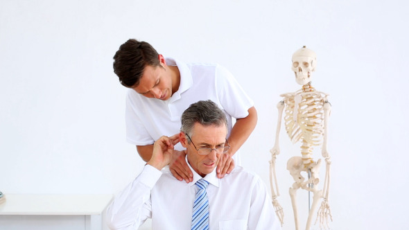 Physiotherapist Giving Businessman A Massage Physiotherapist Giving Businessman A Massage