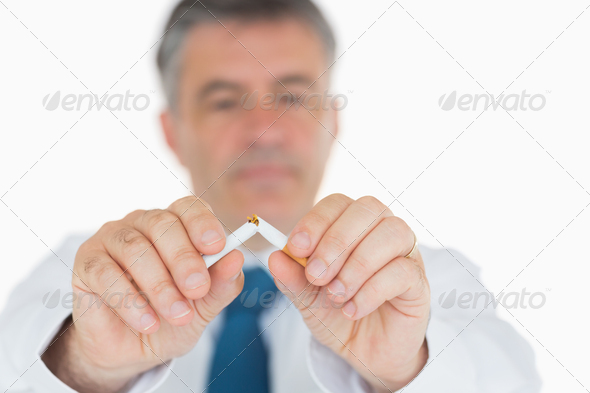 Man in suit breaking cigarette in half (Misc) Photo Download