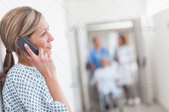 Patient calling in a hospital corridor while smiling (Misc) Photo Download