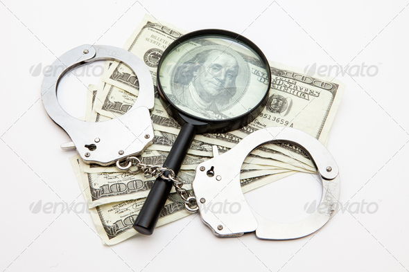 Magnifying glass dollars and handcuffs lying against white background (Misc) Photo Download