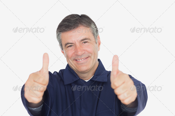 Portrait of mechanic gesturing thumbs up against white background (Misc) Photo Download