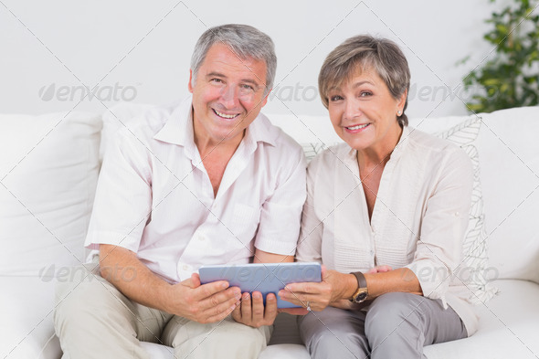 Old couple looking camera with tablet pc in their hands (Misc) Photo Download