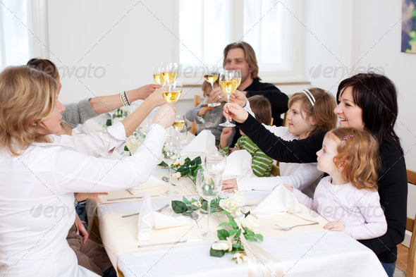 Family And Friends Toasting Wineglasses At Table In Restaurant