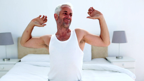 Handsome Man Yawning And Stretching Sitting On Bed Handsome Man Yawning And Stretching Sitting On Bed