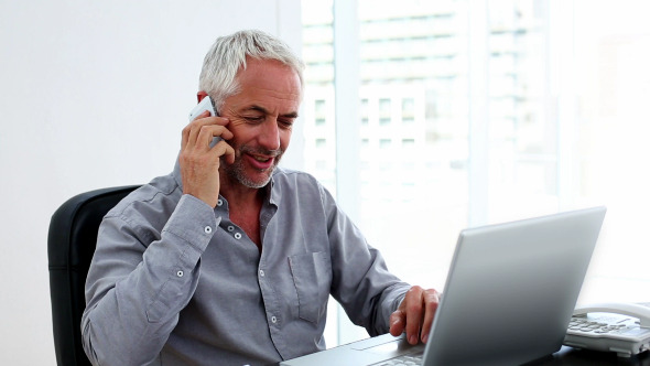 Casual Businessman Working On Laptop And Talking Casual Businessman Working On Laptop And Talking