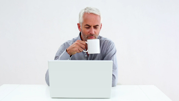 Casual Businessman Working On Laptop And Drinking Casual Businessman Working On Laptop And Drinking