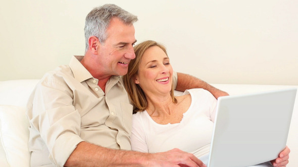 Mature Couple Using Laptop Together On The Couch Mature Couple Using Laptop Together On The Couch