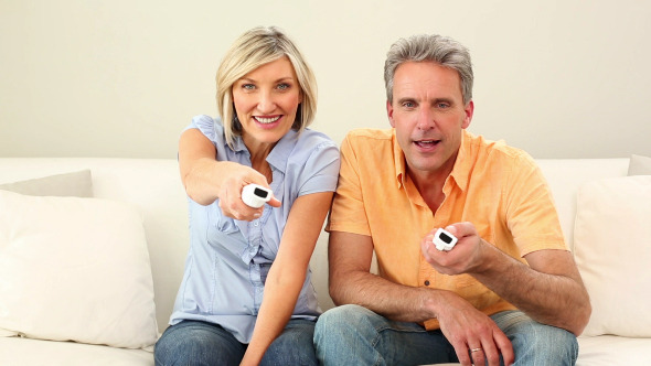 Husband And Wife Playing Video Games On The Couch Husband And Wife Playing Video Games On The Couch
