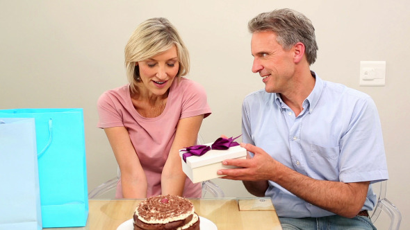 Man Giving His Wife Her Birthday Present Man Giving His Wife Her Birthday Present