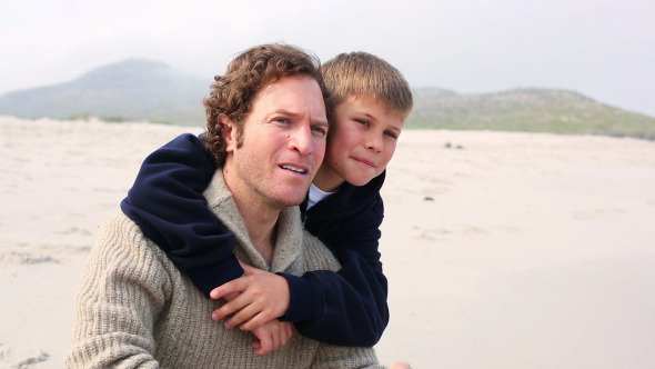 Man Piggybacking His Son At Beach Man Piggybacking His Son At Beach